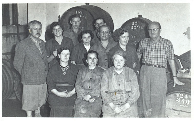 Jan Wojnarowicz (pierwszy z lewej) i Ryszard Siwiec – byli współwłaściciele Wytwórni
        Wina i Miodu – wraz z pracownikami, sierpień 1959 r.
